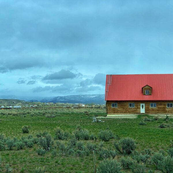 red barn on green grass field under white clouds during daytime